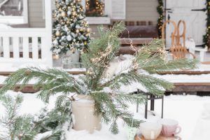 The porch of a country house decorated for Christmas and New Year holidays. Christmas tree on the porch of the house in winter